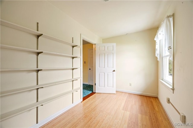 unfurnished bedroom with light wood-style flooring and baseboards