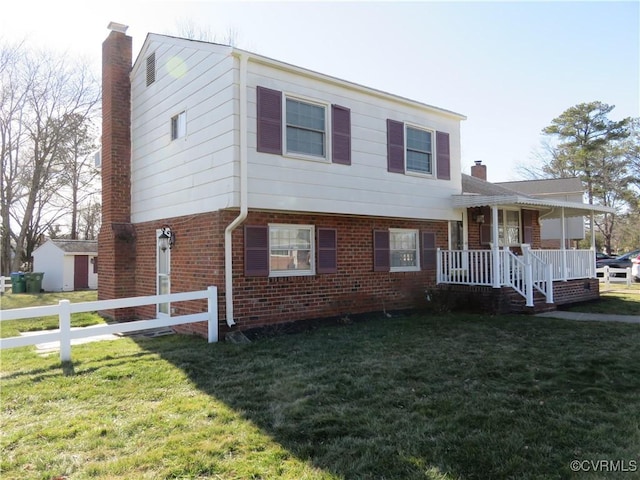 split level home featuring a chimney, a front lawn, and brick siding