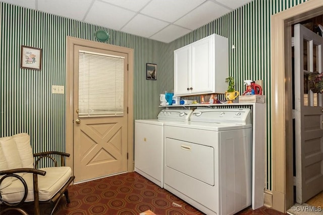 washroom featuring cabinet space, washer and dryer, and wallpapered walls