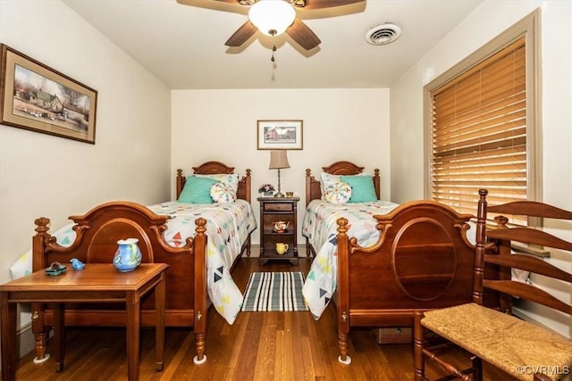 bedroom with a ceiling fan, visible vents, and wood finished floors