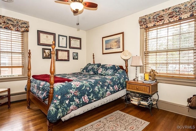 bedroom with ceiling fan, a baseboard radiator, wood finished floors, and baseboards