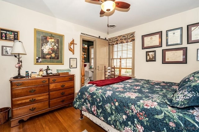 bedroom featuring wood finished floors, visible vents, and a ceiling fan