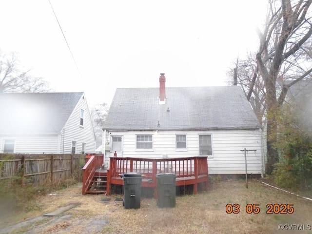 back of house featuring fence and a wooden deck