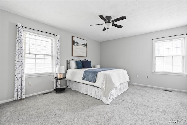 carpeted bedroom with baseboards, visible vents, and a ceiling fan