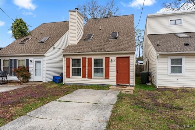 cape cod home with roof with shingles, fence, a chimney, and a front lawn