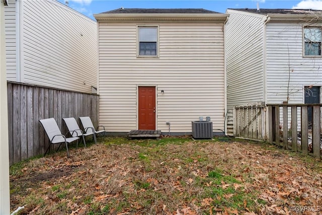 back of property with fence and central AC unit