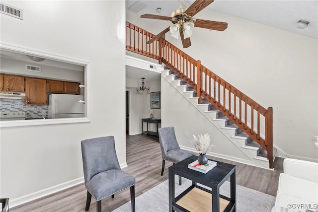 interior space featuring stairway, visible vents, light wood-style flooring, and baseboards