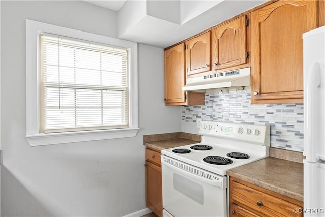 kitchen featuring white appliances, under cabinet range hood, brown cabinetry, and backsplash