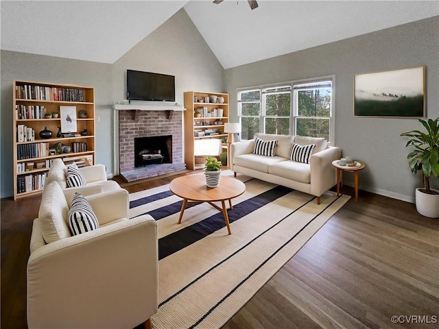 living room featuring high vaulted ceiling, a brick fireplace, baseboards, and wood finished floors