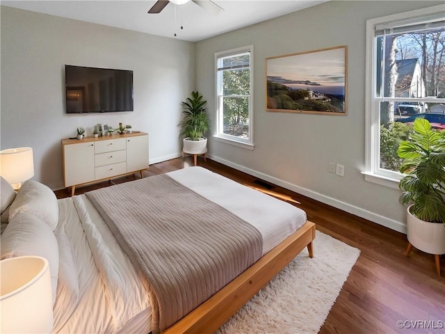 bedroom with visible vents, ceiling fan, baseboards, and wood finished floors