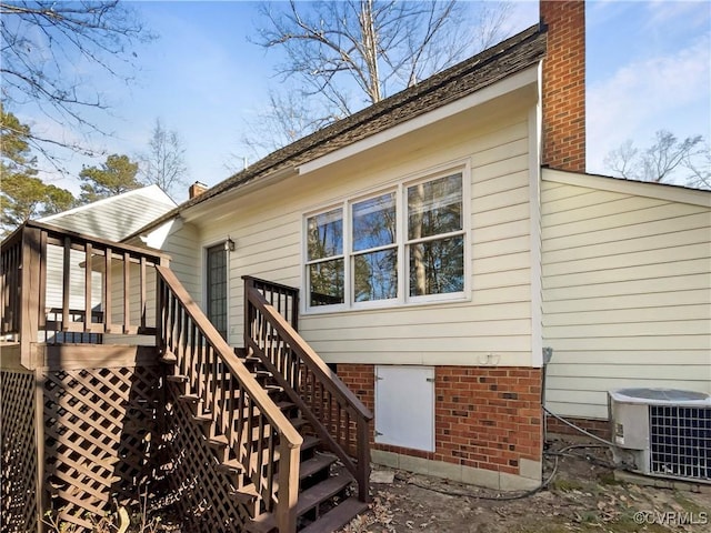 rear view of property with stairway, cooling unit, a chimney, and a deck