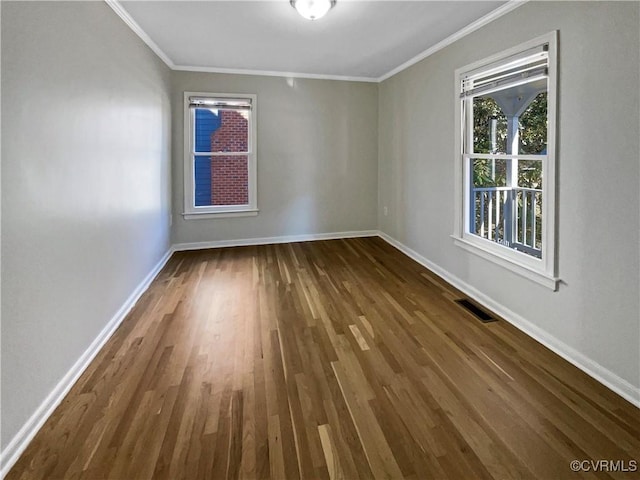 unfurnished room with ornamental molding, visible vents, baseboards, and wood finished floors