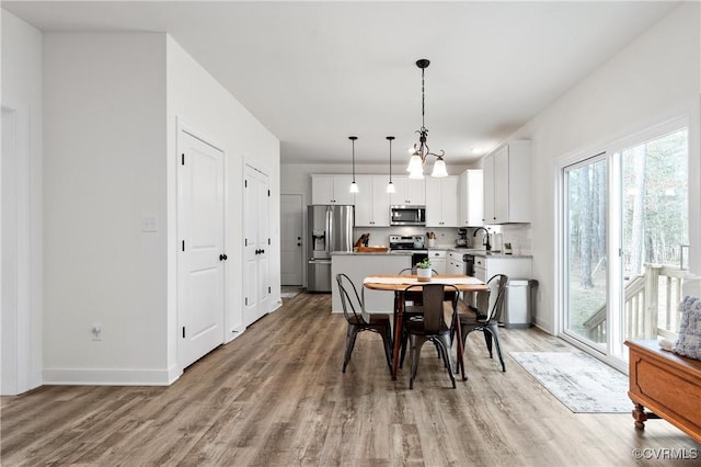 dining area featuring light wood-type flooring and baseboards