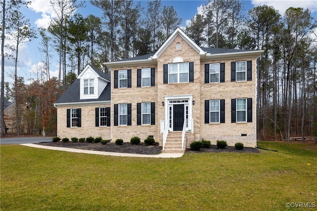 colonial home featuring brick siding, crawl space, and a front yard