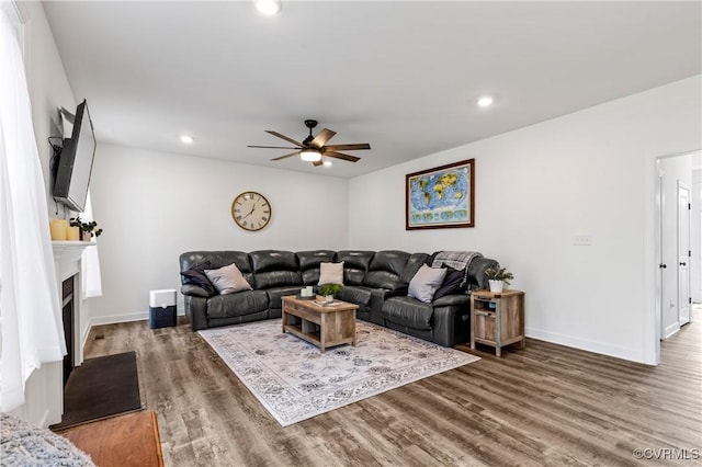 living area with baseboards, wood finished floors, and recessed lighting