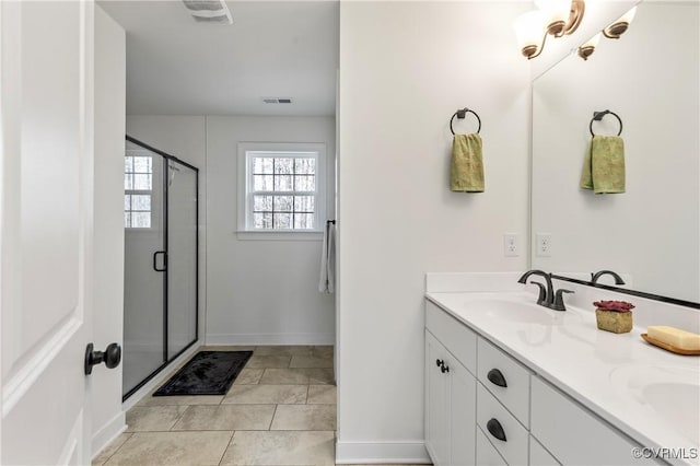 bathroom with tile patterned flooring, a sink, visible vents, a shower stall, and double vanity