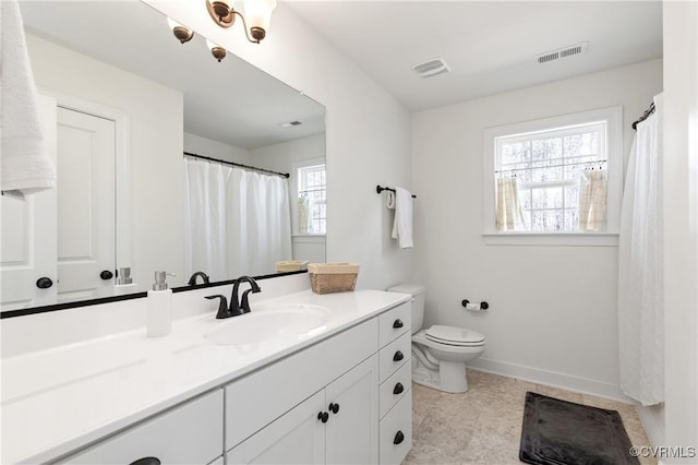 bathroom featuring visible vents, toilet, vanity, and baseboards