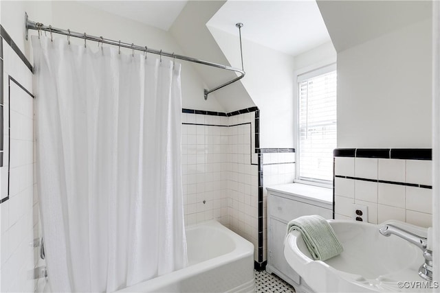 full bath featuring tile walls and shower / bath combo