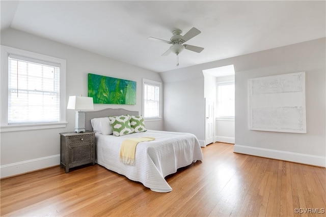 bedroom with baseboards, lofted ceiling, light wood-style floors, and a ceiling fan