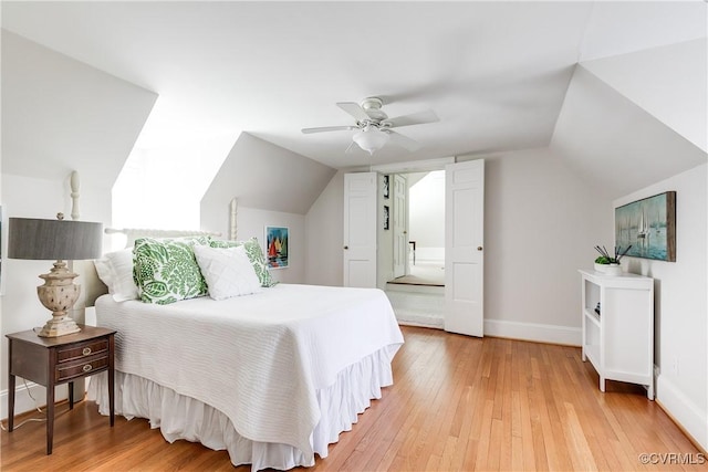 bedroom featuring a ceiling fan, lofted ceiling, light wood-style floors, and baseboards