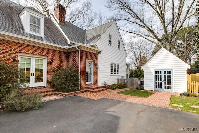 exterior space with french doors, fence, brick siding, and entry steps