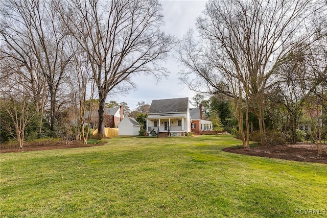 view of front of house featuring a front yard, covered porch, and a chimney