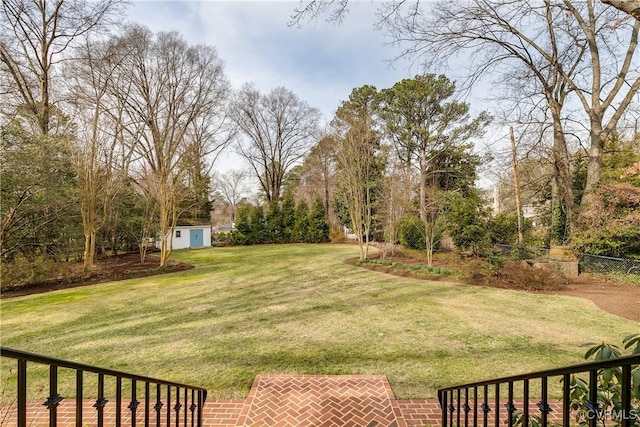 view of yard featuring an outbuilding, a shed, and fence