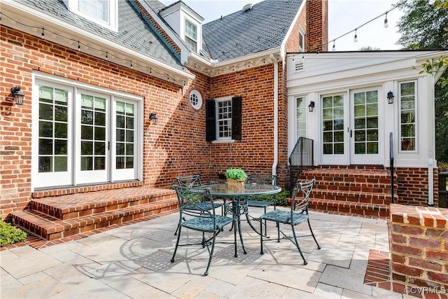 view of patio with outdoor dining space, french doors, and entry steps