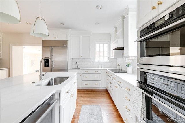 kitchen featuring light countertops, light wood-style floors, appliances with stainless steel finishes, and a sink