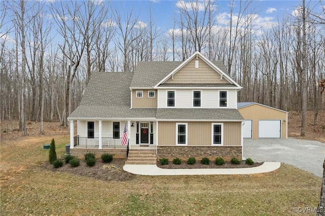 craftsman house with an outbuilding, stone siding, covered porch, and a shingled roof