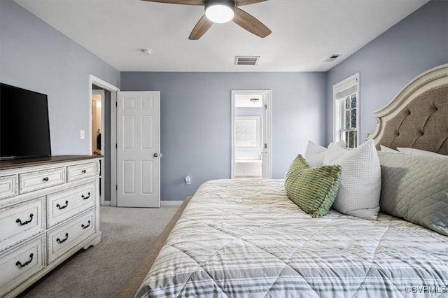 bedroom with light colored carpet, connected bathroom, visible vents, and baseboards