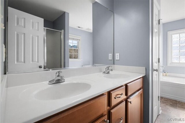 bathroom with double vanity, a stall shower, a garden tub, and a sink