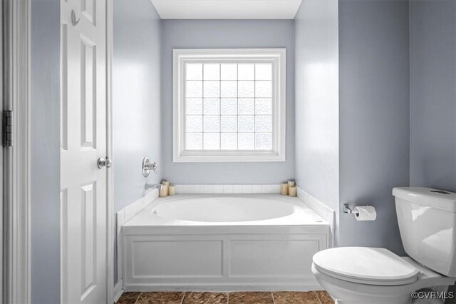 bathroom with toilet and a garden tub