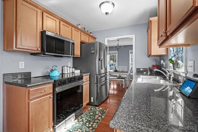 kitchen featuring black electric range, plenty of natural light, dark wood-type flooring, and a sink