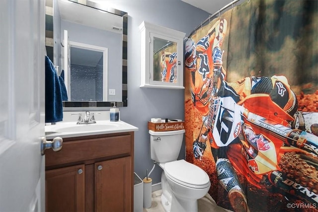 bathroom featuring baseboards, vanity, and toilet