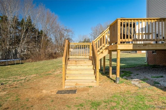 exterior space with a trampoline, a yard, and stairway