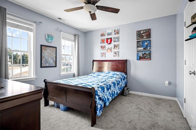 bedroom featuring light carpet, ceiling fan, visible vents, and baseboards