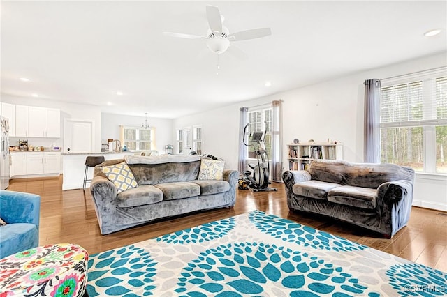 living area with light wood-type flooring, a ceiling fan, and recessed lighting