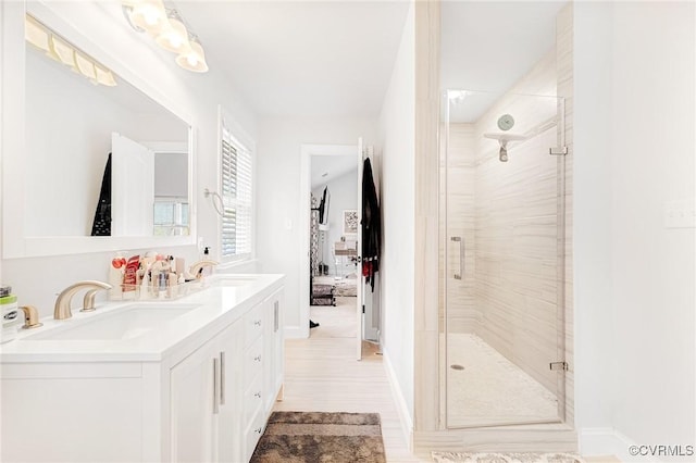 bathroom with double vanity, a stall shower, and a sink