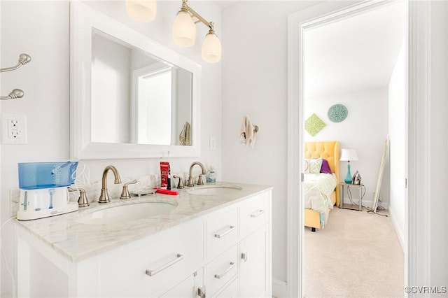 full bathroom with double vanity, a sink, baseboards, and ensuite bathroom