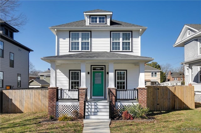 traditional style home with fence, a porch, and roof with shingles