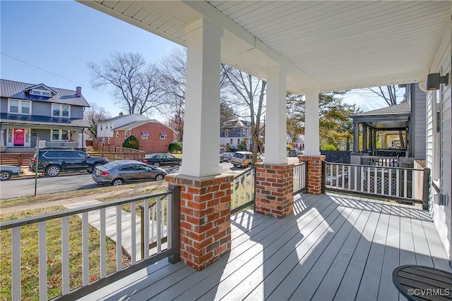 wooden deck with covered porch and a residential view