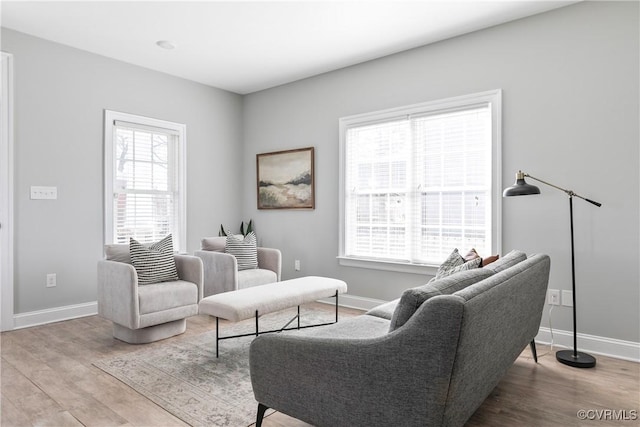 living area featuring plenty of natural light, baseboards, and wood finished floors