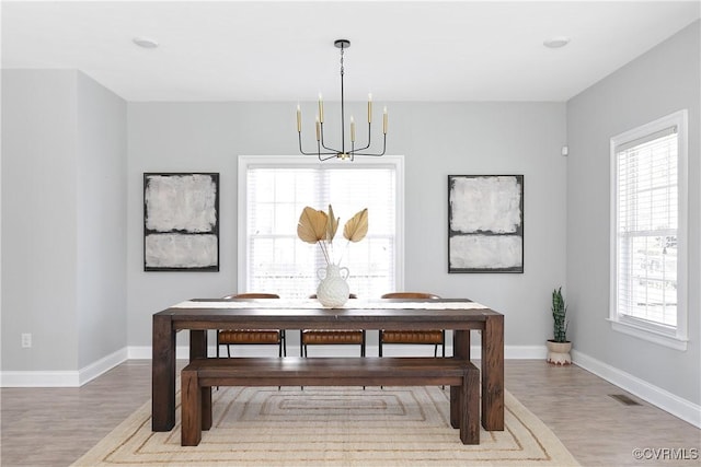 dining area featuring plenty of natural light, wood finished floors, and visible vents