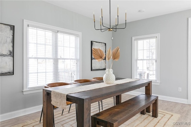 dining room featuring a healthy amount of sunlight, light wood-type flooring, and baseboards