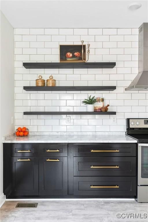 bar featuring visible vents, light wood-style floors, electric stove, wall chimney exhaust hood, and tasteful backsplash