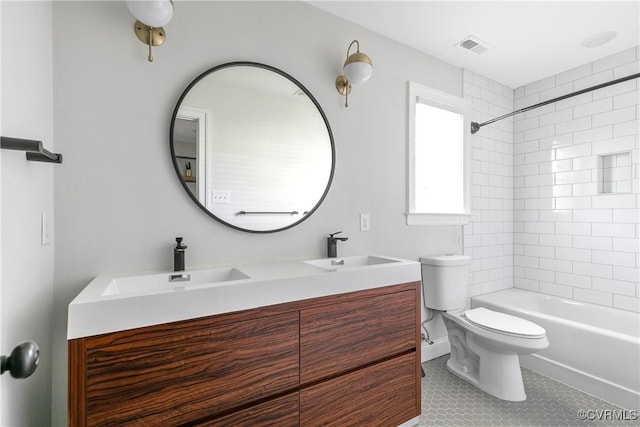 full bath with visible vents, a sink, toilet, and double vanity