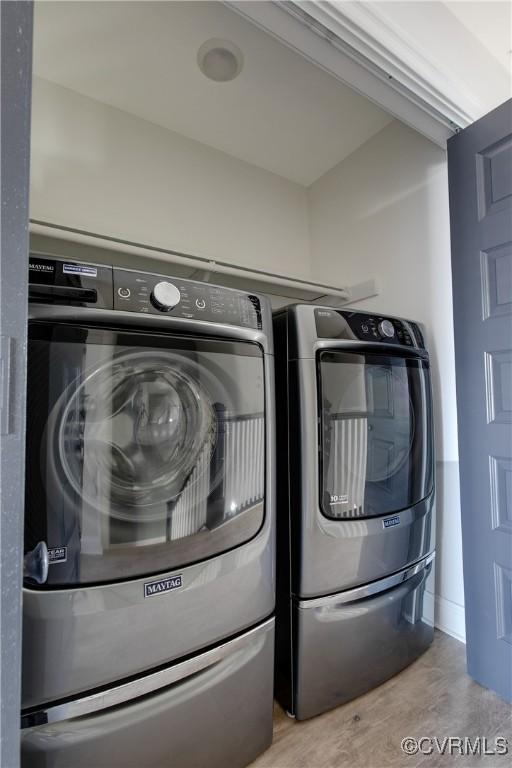 laundry area with laundry area, light wood finished floors, and separate washer and dryer