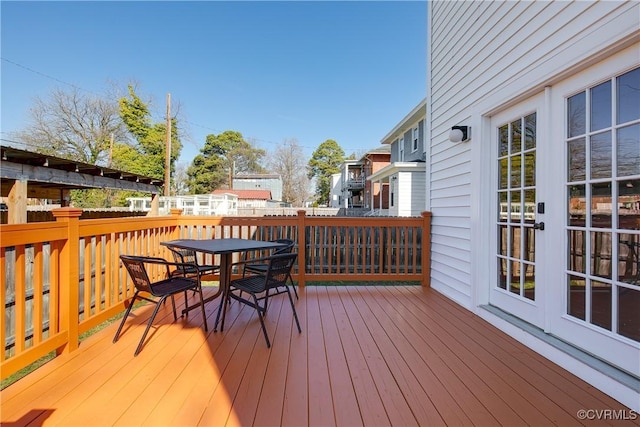 wooden terrace featuring outdoor dining space and a residential view