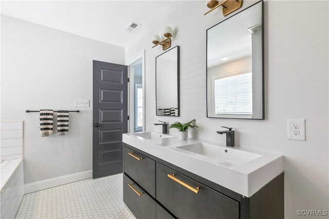 bathroom featuring double vanity, baseboards, visible vents, and a sink